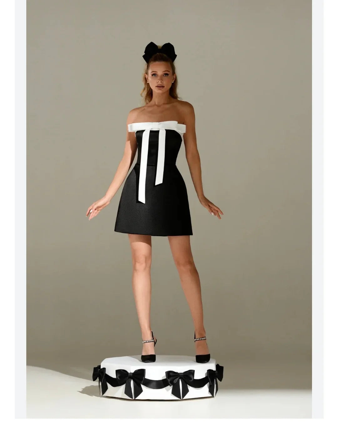 Amstoosh black strapless tube mini dress with front bow detailing — on model