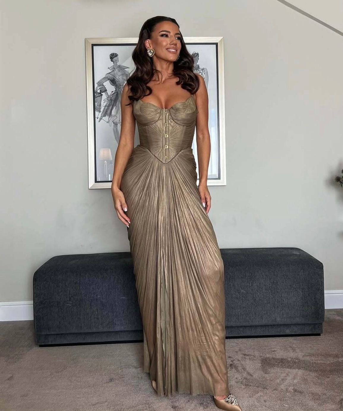 Gold metallic strapless corset-bodice gown with vertical pleated draped floor-length skirt